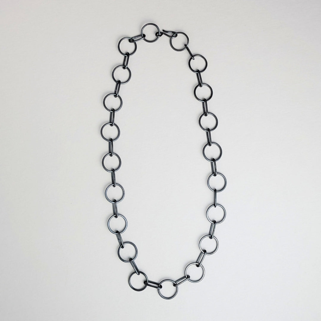 A sterling silver circle chain necklace with a hand-fabricated S-clasp, displayed on a white background.