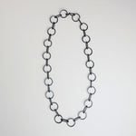 A sterling silver circle chain necklace with a hand-fabricated S-clasp, displayed on a white background.